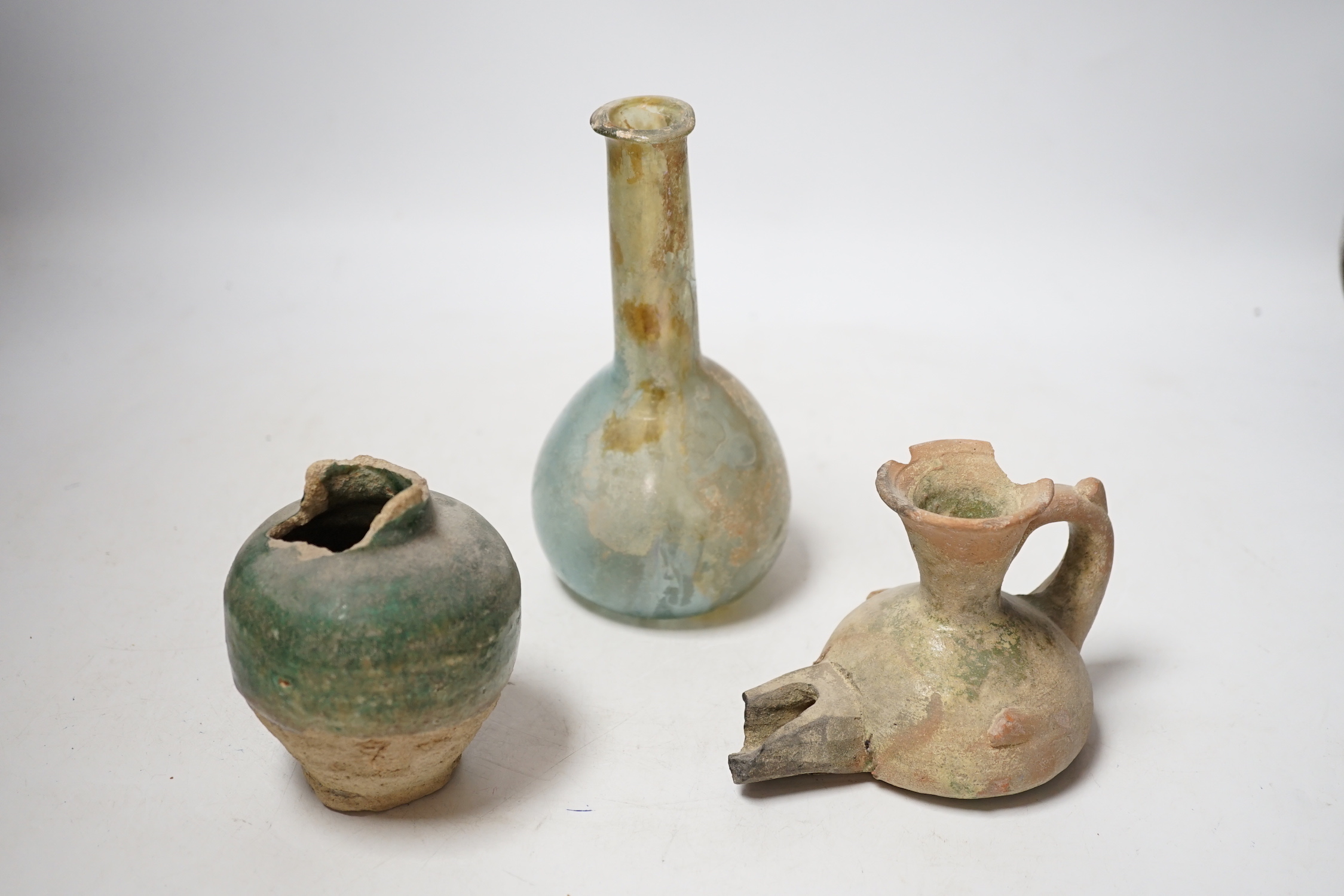 A Roman glass vessel, an Islamic pot and oil lamp, largest 18cm high (3)